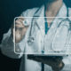 Digitally edited photo of a doctor pressing a holographic AI screen with health details on it.